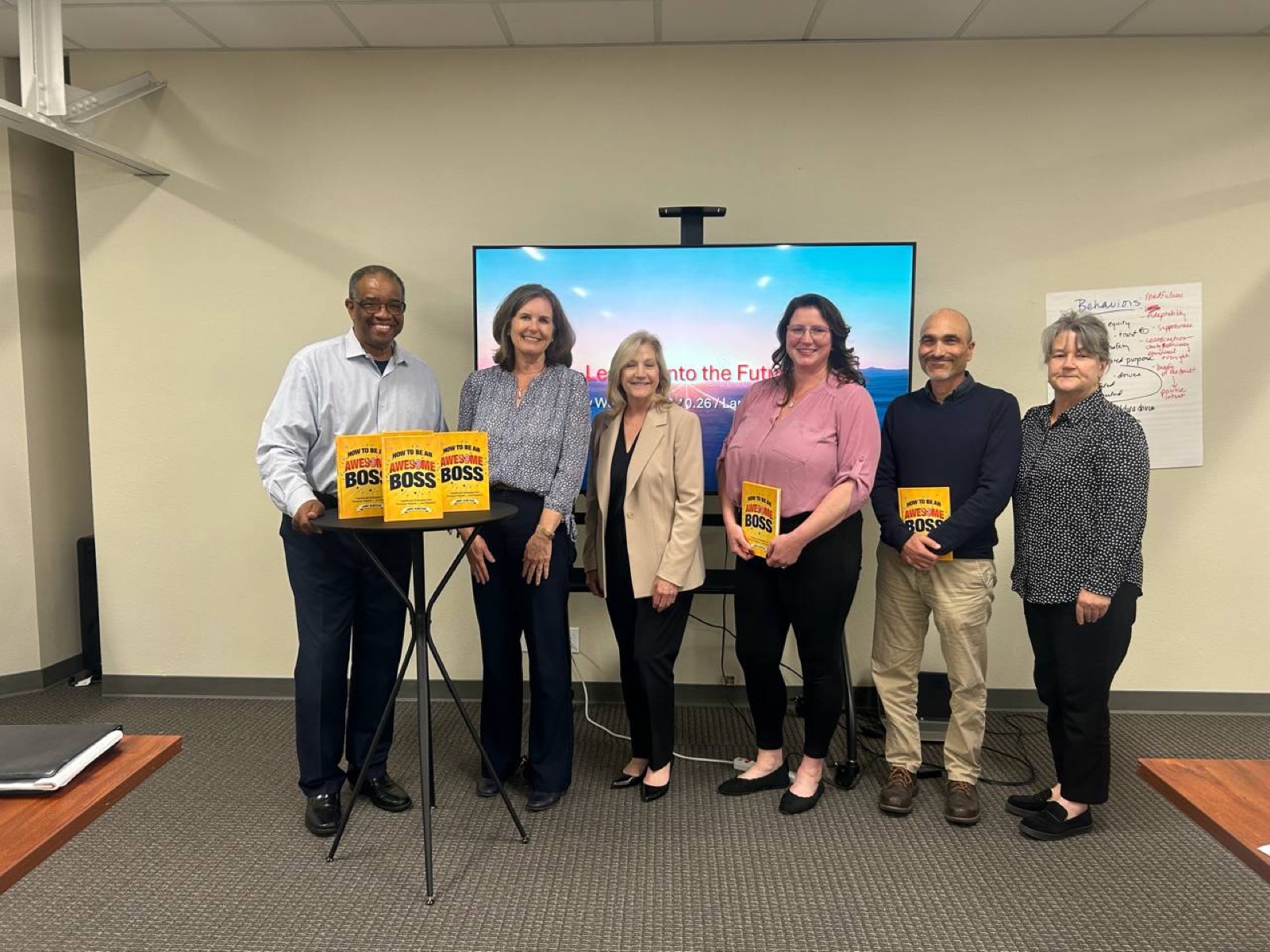Larry Olmstead with the Monterey leadership team holding copies of the book